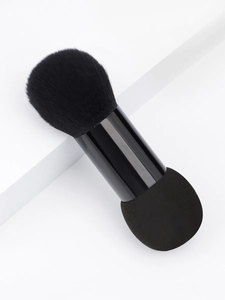 Close-up of a dual-ended makeup brush with soft fiber bristles and a black blending sponge