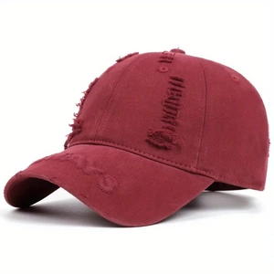 Close-up of distressed burgundy cotton baseball cap with vintage frayed edges and embroidery