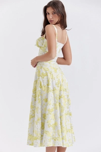Detailed shot of yellow floral summer dress featuring spaghetti straps and waist tailoring
