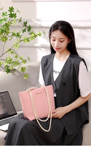 Detailed macro view of pink quilted wave texture and rope handle on tote bag