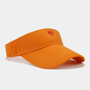 Detailed view of orange sun visor with red heart embroidery on cotton twill fabric