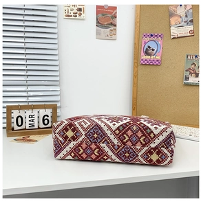 Detailed view of colorful geometric diamond pattern on ethnic style woven canvas bag