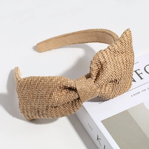 Macro shot of straw woven bow headband with natural raffia texture and fine weaving details