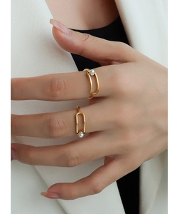 Detailed close-up of geometric gold-plated titanium ring set with elegant white pearls