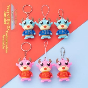 Detail view of cartoon ox soft glue charms with keychain, elastic rope, and bead chain options