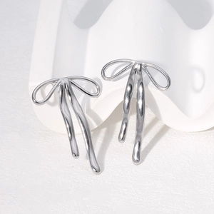 Détail macro de boucles d'oreilles nœuds argentées avec finition polie et design élégant