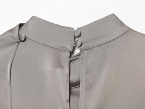 Detalle de camisa de satén gris con elegante cuello alto y dos botones de tela