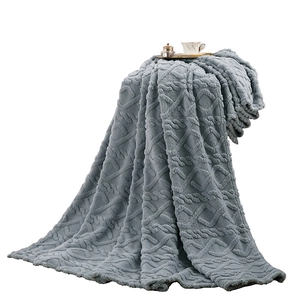 Grey Sherpa fleece blanket with textured knit pattern and coffee cup on white background