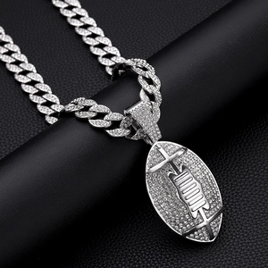 Close-up of silver American football pendant with pavé rhinestones on a Cuban link chain