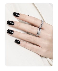 Close-up of silver feather texture ring and sparkling pavé band on a model hand