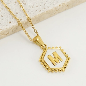 Hexagonal 18K gold titanium steel necklace featuring a white shell letter M pendant