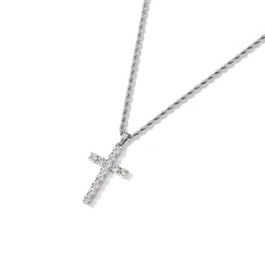 Détail d'un pendentif croix en argent avec cristaux pavés sur une chaîne torsadée