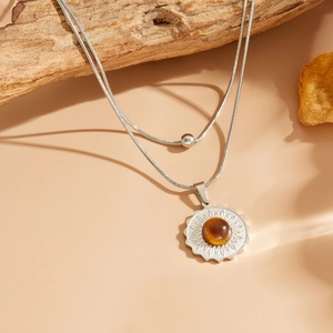 Détail de la chaîne serpent argentée avec pendentif tournesol et pierre d'ambre