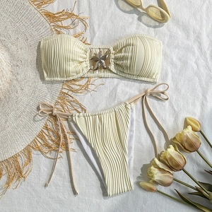 Detail of cream pleated bandeau bikini top with metallic starfish charm and tie-side bottoms