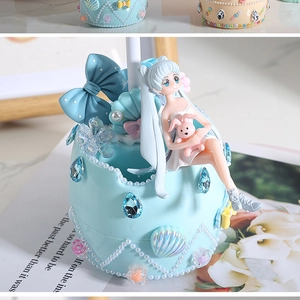 Dettaglio dell'organizzatore da scrivania fai-da-te azzurro con figurina e perle