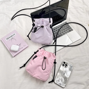 Posa piatta di borse a tracolla con coulisse rosa e viola con gadget su tessuto