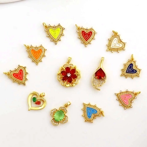 Flat lay of colorful heart and flower heart-shaped copper pendants with zircon stones