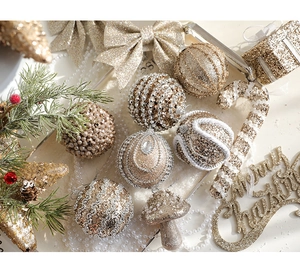 Flat lay of champagne gold Christmas ornaments including glitter balls and pearl canes