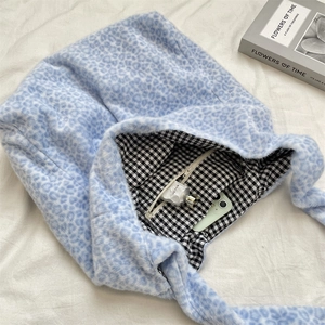 Detailed view of plush light blue leopard tote with checkered lining and inner zipper pocket