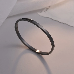 Vista de cerca de un brazalete negro de acero inoxidable con acabado pulido brillante