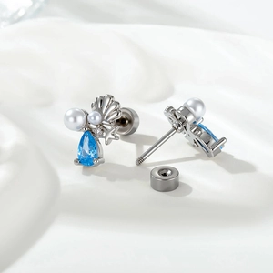 Blue zircon starfish and shell stud earrings with pearls on white silk background