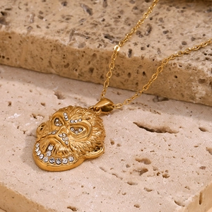 Gros plan d'un pendentif tête de gorille plaqué or 18K avec cristaux sur chaîne en O