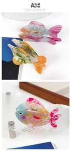 Detailed view of fish-shaped acetate hair claw clips with marble texture and gradients