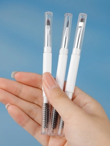 Close-up of double-ended makeup brushes with soft bristles and clear dustproof caps