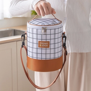 Insulated cylindrical lunch bag with black and white plaid pattern and shoulder strap