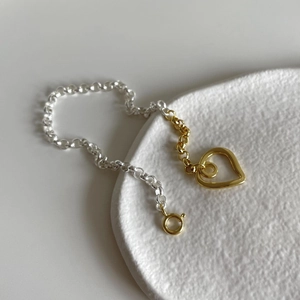 Detail of S925 silver heart bracelet featuring gold and silver dual-tone chain design