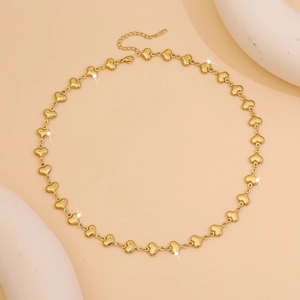 Detailed close-up of golden heart link choker necklace with extension chain and lobster clasp