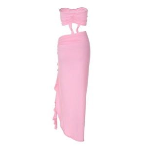 Detail view of pink tube top and ruched high slit skirt with ruffle hemline accents