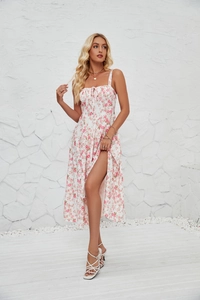 Detail of floral spaghetti strap dress with side slit and pink flower print on white fabric