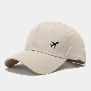 Détail de la broderie avion sur une casquette de baseball en coton beige à visière courbée