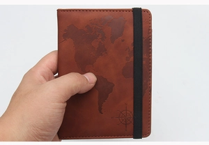 Detailed close-up of brown leather passport holder with embossed world map and elastic strap