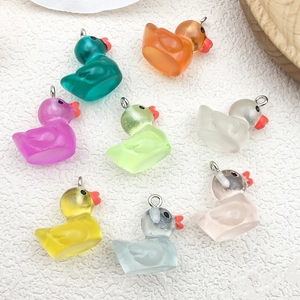 Colorful mini luminous resin ducks in various shades on a textured background