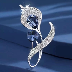 Elegant silver flower brooch with sparkling blue crystals and white rhinestones