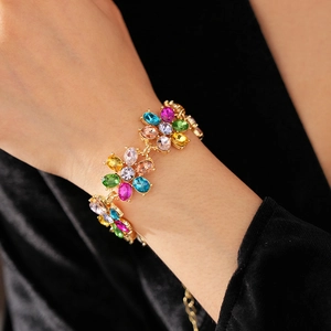Detail of vintage flower bracelet with multicolored rhinestones on gold base