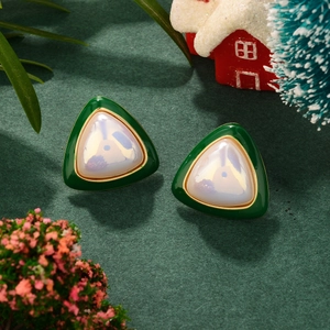 French luxury triangle green enamel earrings with pearl detail and festive background