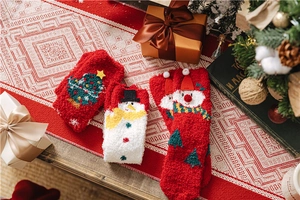 Detailed view of festive coral fleece Christmas socks with snowman and tree patterns