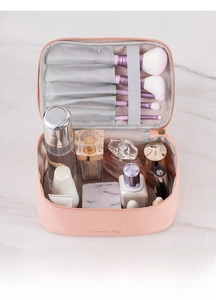 Detail view of the pink cosmetic bag featuring organized makeup brush slots and inner pockets