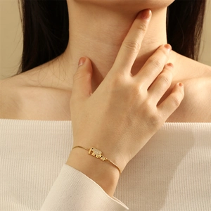 Detail of adjustable gold elephant bracelet with sparkling zircons on model's wrist