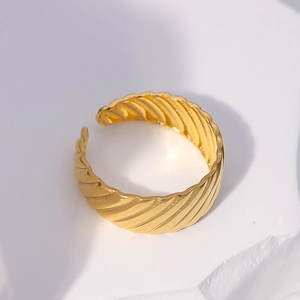 Detail of 18k gold plated stainless steel twist ring on a white marble stone