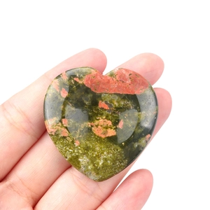 Polished Unakite heart worry stone held in hand showing palm size and texture