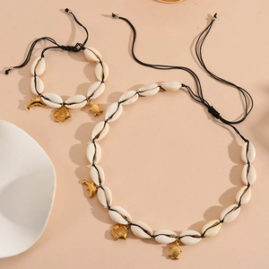 Detail of seashell jewelry set with golden dolphin, fish, and turtle metal charms