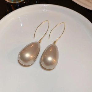 Gros plan détaillé de boucles d'oreilles perles gouttes champagne avec crochets dorés