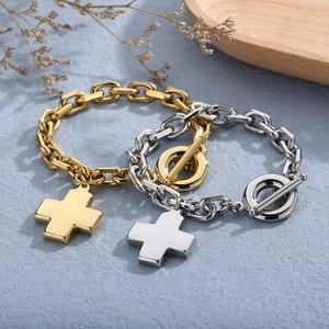 Detail view of gold and silver cross pendant necklaces with toggle clasp closure