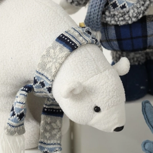 Polar bear plush toy with blue snowflake scarf and textured white curly fur decoration
