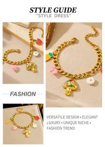Detail of gold chain bracelet featuring colorful mushroom, carrot and flower charms