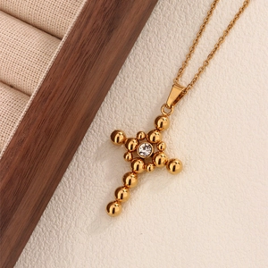 Vintage gold cross necklace with stacked bead design and central cubic zirconia pendant